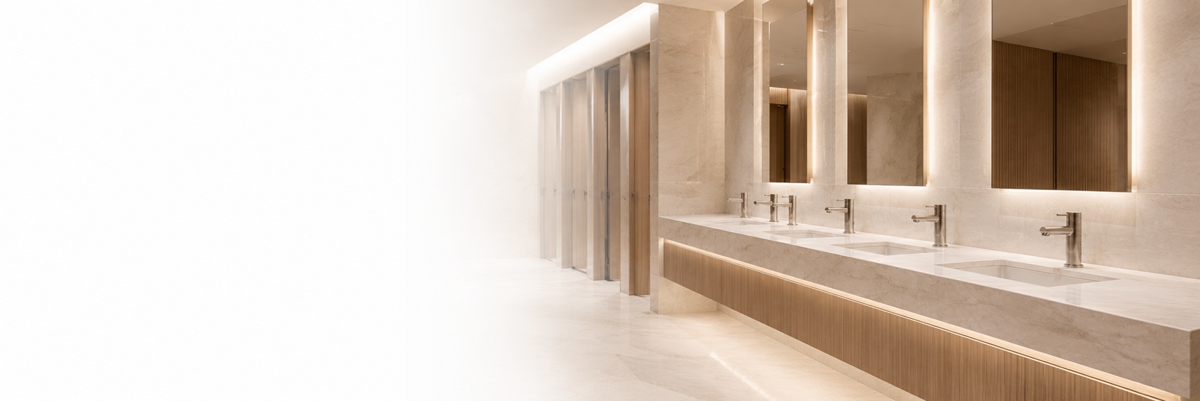 BathSelect� Architecture Touchless Faucets in a contemporary architectural restroom with coordinated sensor faucets, integrated sinks, mirrors, and ambient lighting